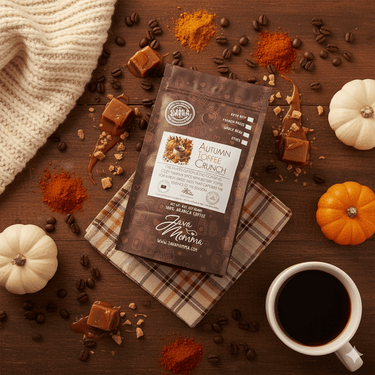 Packaged coffee labeled 'Autumn Toffee Crunch' on a wooden surface with coffee beans, pumpkins, and a cup of coffee.